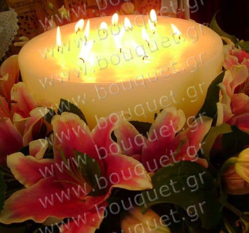 Big candle surrounded by oriental lilies